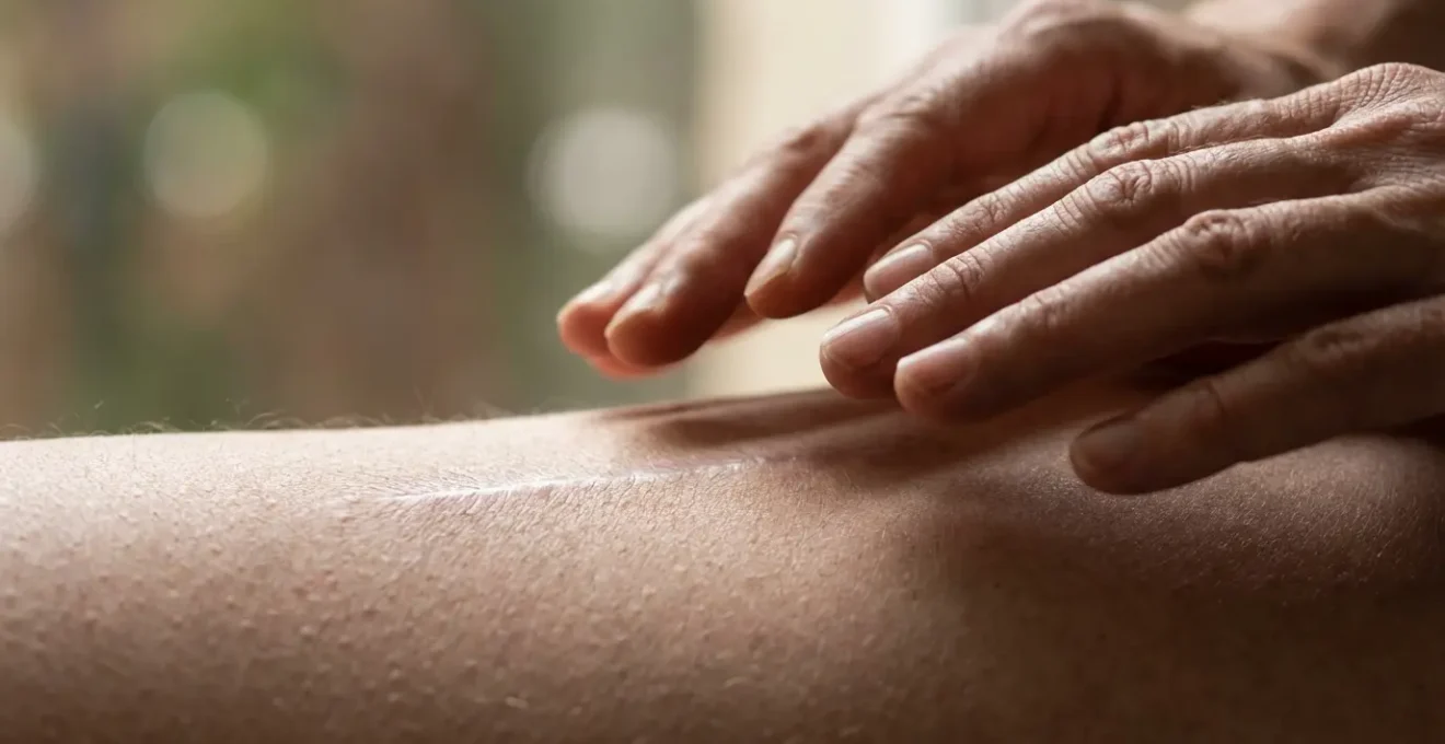 Mani che emanano luce dorata sopra una cicatrice in processo di guarigione energetica